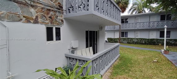 Front view of a two-story building with balconies featuring decorative railings.