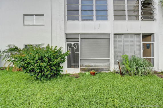 Front view of a building with large windows and a grass lawn.