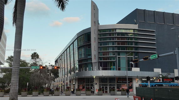 Front view of a modern building with large glass windows and a vertical sign reading 'LINCOLN'.