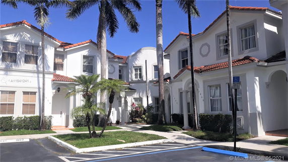 Front view of two-story residential building with white walls and red-tiled roofs.