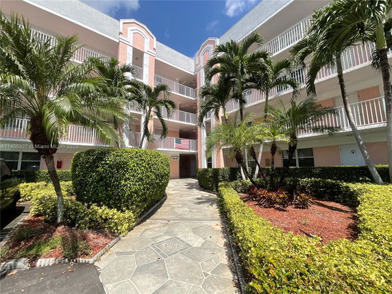 Front view of a multi-story building with balconies and pink facade.