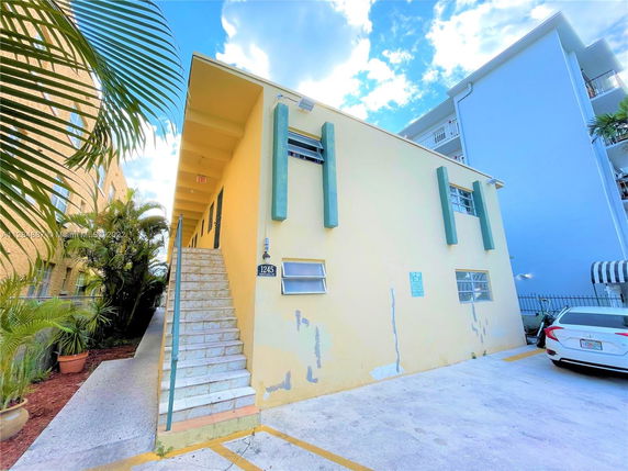 Front view of a two-story building with stairs leading to the upper level.