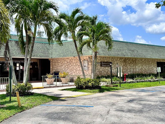 Front view of a building with stone facade and green shingle roof.
