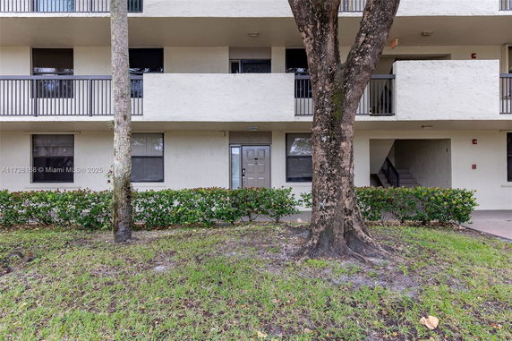 Front view of a multi-story building with balconies and a central entrance.