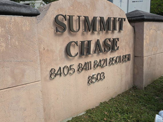 Stone sign with the words 'Summit Chase' and addresses displayed on it.