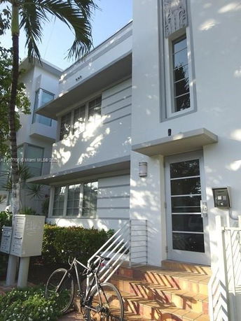 Front view of a modern two-story building with a bicycle in front.