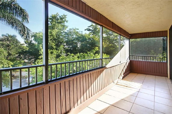 Screened balcony view with surrounding trees.