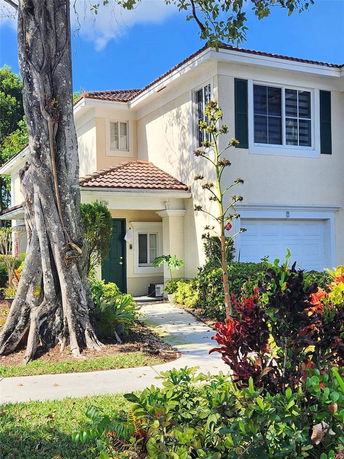 Front view of a two-story house with a white exterior and a double garage.