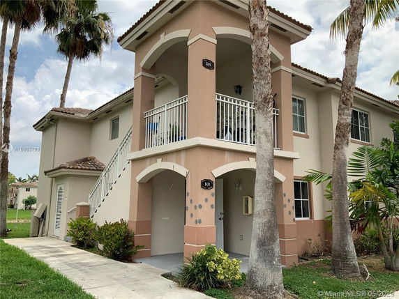 Front view of a two-story residential building with an external staircase and balcony.