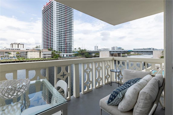 View from a balcony overlooking a river with high-rise buildings in the background.