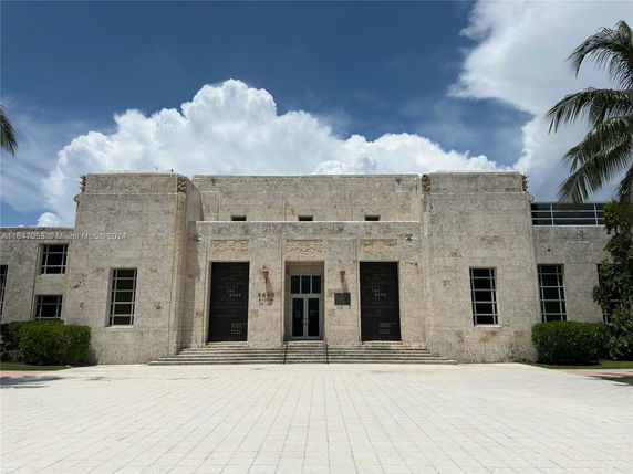 Front view of a building with a stone exterior and symmetrical windows.
