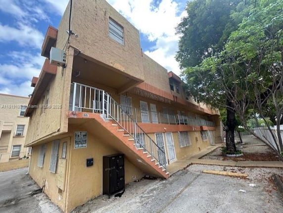 Front view of a multi-story residential building with external staircase.