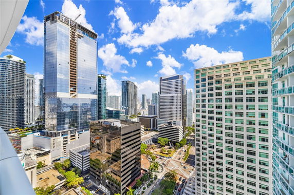 A panoramic view of a cityscape with multiple high-rise buildings and blue sky.