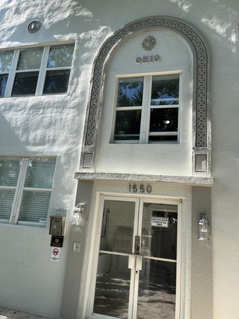 Front view of a building with an arched window and entrance.