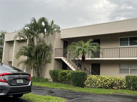 Front view of a two-story apartment building with external staircase.