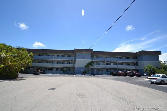 Front view of a three-story apartment building with balconies.