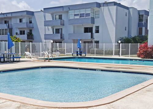 Outdoor swimming pool area with apartment buildings in the background.