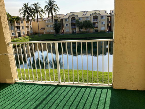 View from a balcony overlooking a water body and residential buildings.