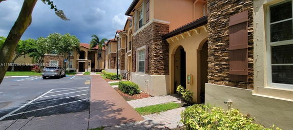 Front view of a two-story residential building with stone accents and beige exterior.