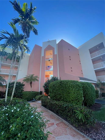 Front view of a multi-story building with a central entrance and balconies.