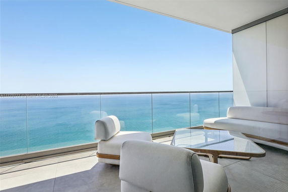 Panoramic view from a modern balcony overlooking the ocean.