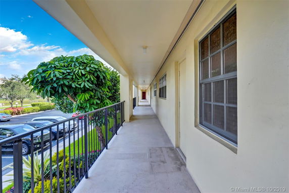 Exterior corridor view with railing and landscaping
