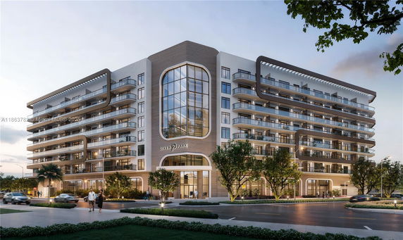 Front view of a modern multi-story apartment building with a distinctive central glass section.