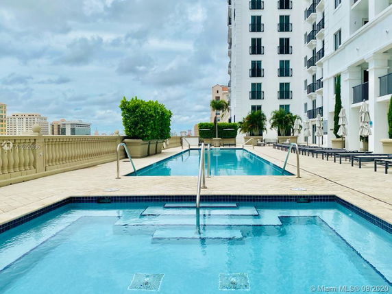 Rooftop view featuring a swimming pool and lounge area on a high-rise building.