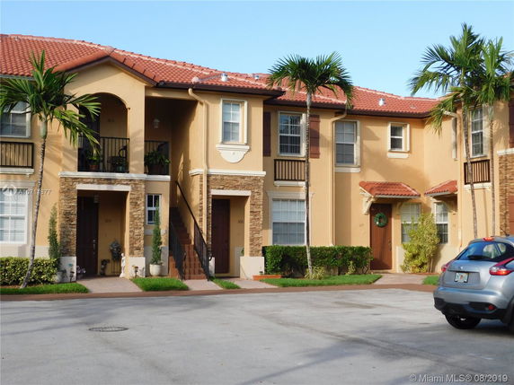 Front view of a two-story house with an orange tiled roof and balconies.
