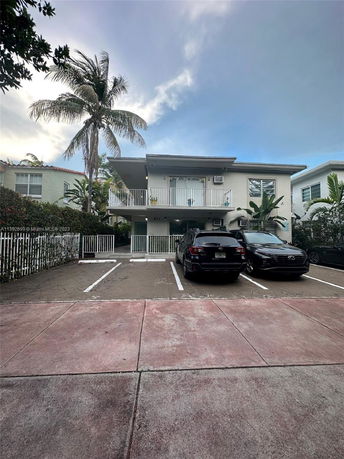 Front view of a two-story house with parking area in front.