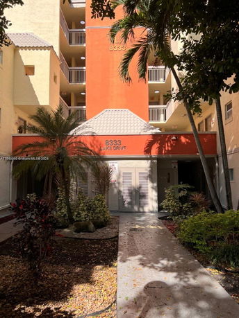 Front view of a multi-story building with balconies and a prominent orange section.