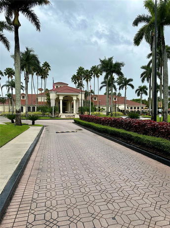 Front view of a large building with a red-tiled roof and tall columns at the entrance.