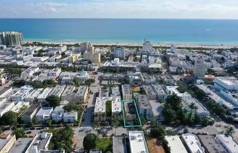 Aerial view of a coastal city with several buildings and the ocean in the background.
