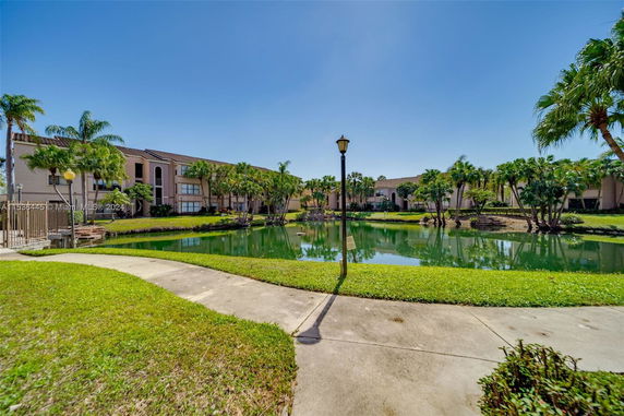 View of surrounding area with a pond and residential buildings
