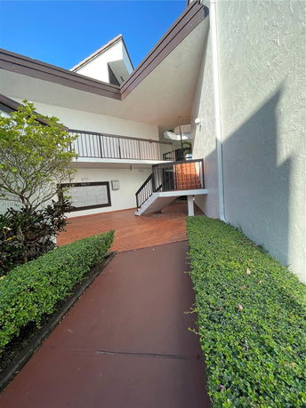 Front view of a building with an outdoor staircase and railings.