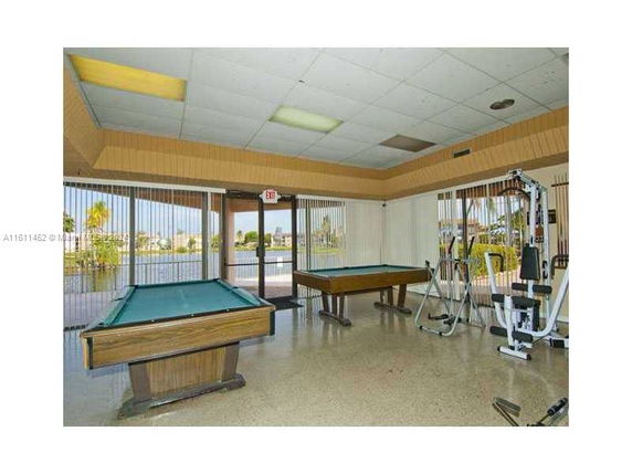 Room with billiard tables and gym equipment.