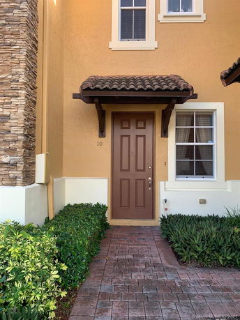 Front view of a house entrance with a brown door and small canopy.