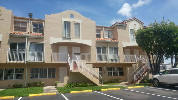 Front view of a multi-story residential building with balconies and external staircases.