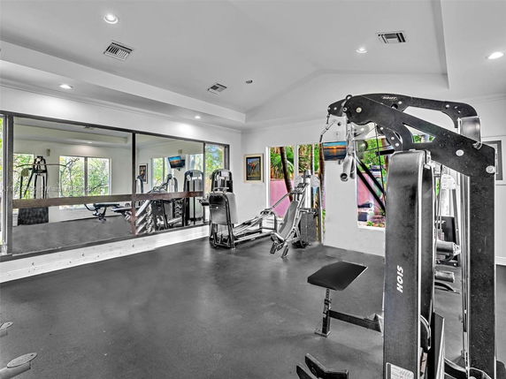 Indoor gym area with fitness equipment and large mirrors.