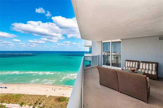 Balcony view of ocean and beach from a high-rise building.