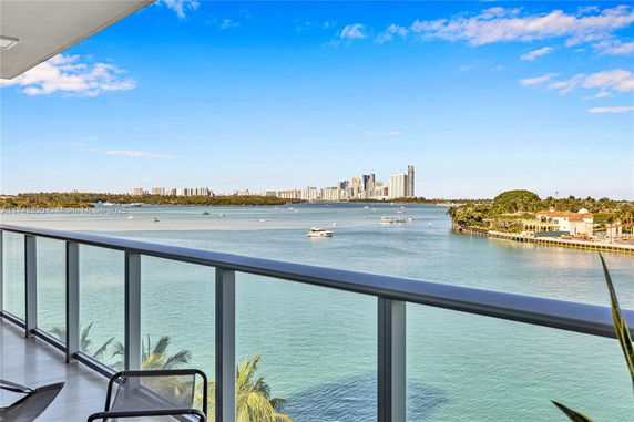 Panoramic view of water and city skyline from a balcony.