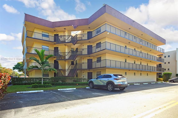 Front view of a multi-story building with balconies and external staircases.
