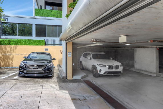 Covered parking area with two cars, a black sedan and a white SUV.