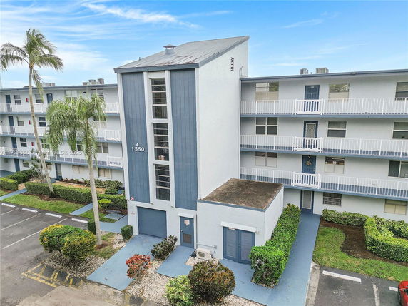 Front view of a multi-story residential building with balconies and a central entrance.