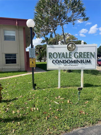 Front view of a condominium complex with a sign reading 'Royale Green Condominium'.