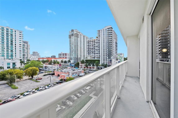 View from a balcony overlooking a cityscape with tall buildings.
