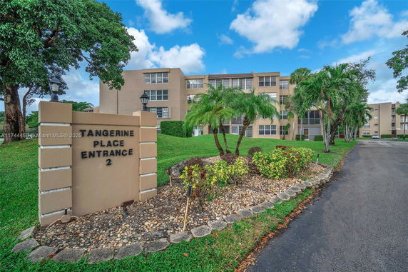 Front view of a multi-story apartment building with a sign indicating Tangerine Place Entrance 2.