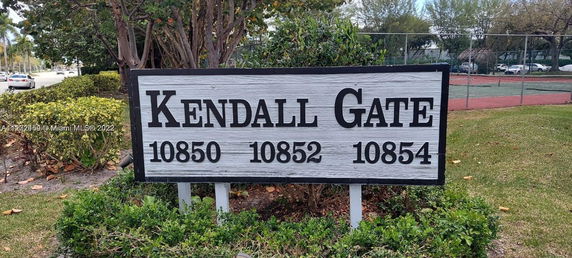 Sign with addresses at Kendall Gate with tennis court in the background.