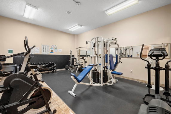 Indoor gym area with exercise equipment and mirrored walls.