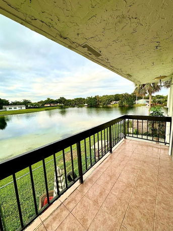 View from a balcony overlooking a lake and surrounding greenery.